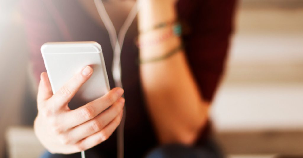 woman listening to podcast on smartphone