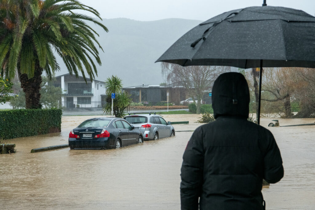 person holding umbrella during flood