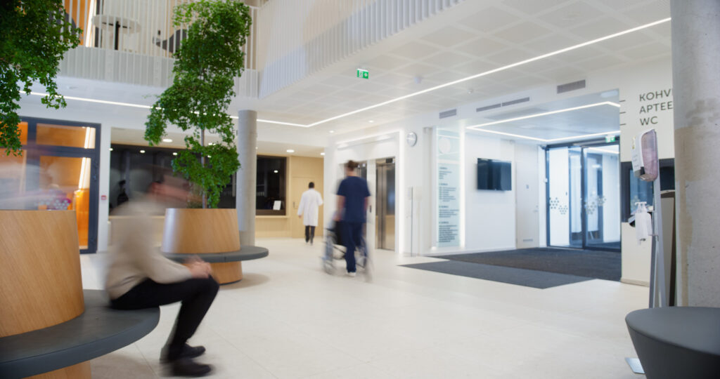 Motion Blur in Modern Hospital Lobby with a Busy Flow of Patients, Visitors, and Staff. Doctors, Nurses and Specialists Working in Clinic. Female and Male Healthcare Officials Walking in a Hall